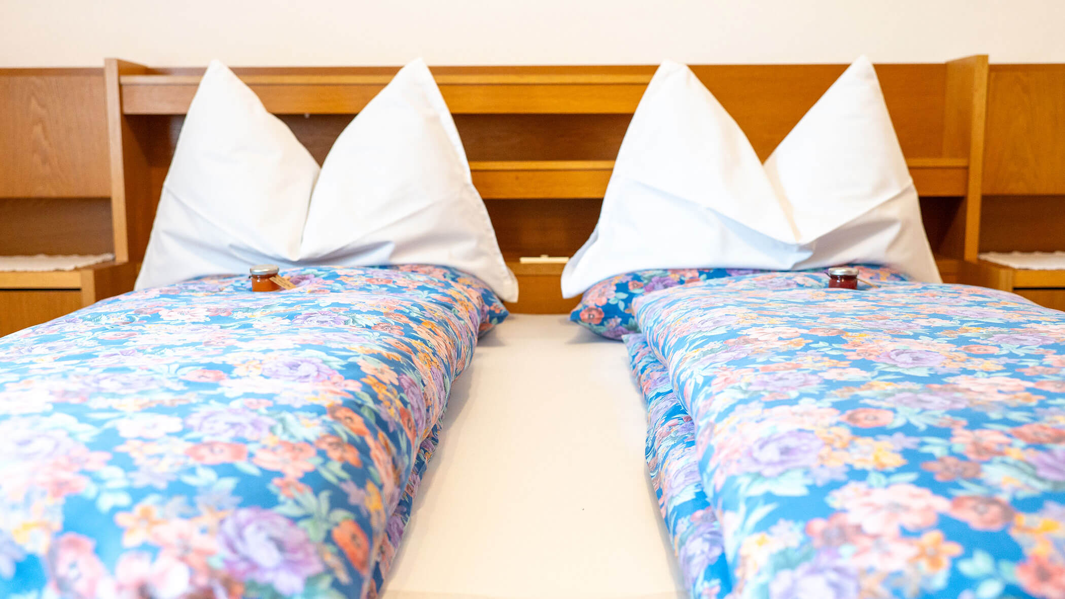 Doppelbett mit Begrüßungsgeschenk darauf in der Ferienwohnung Alpenrose - Villa Taschler
