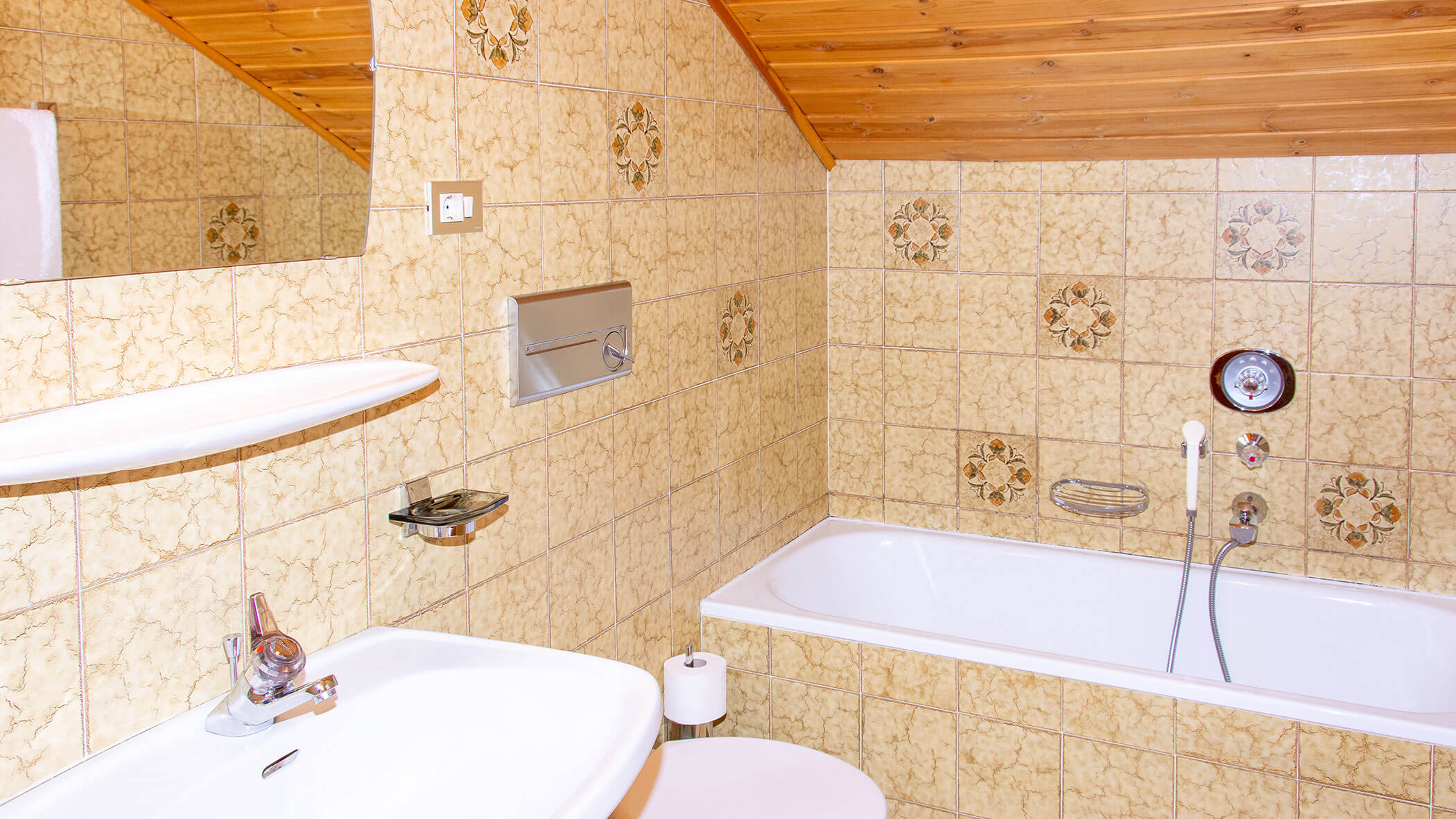 Badezimmer mit Waschbecken, Spiegel, WC und Badewanne in der Ferienwohnung Pfannhorn - Villa Taschler
